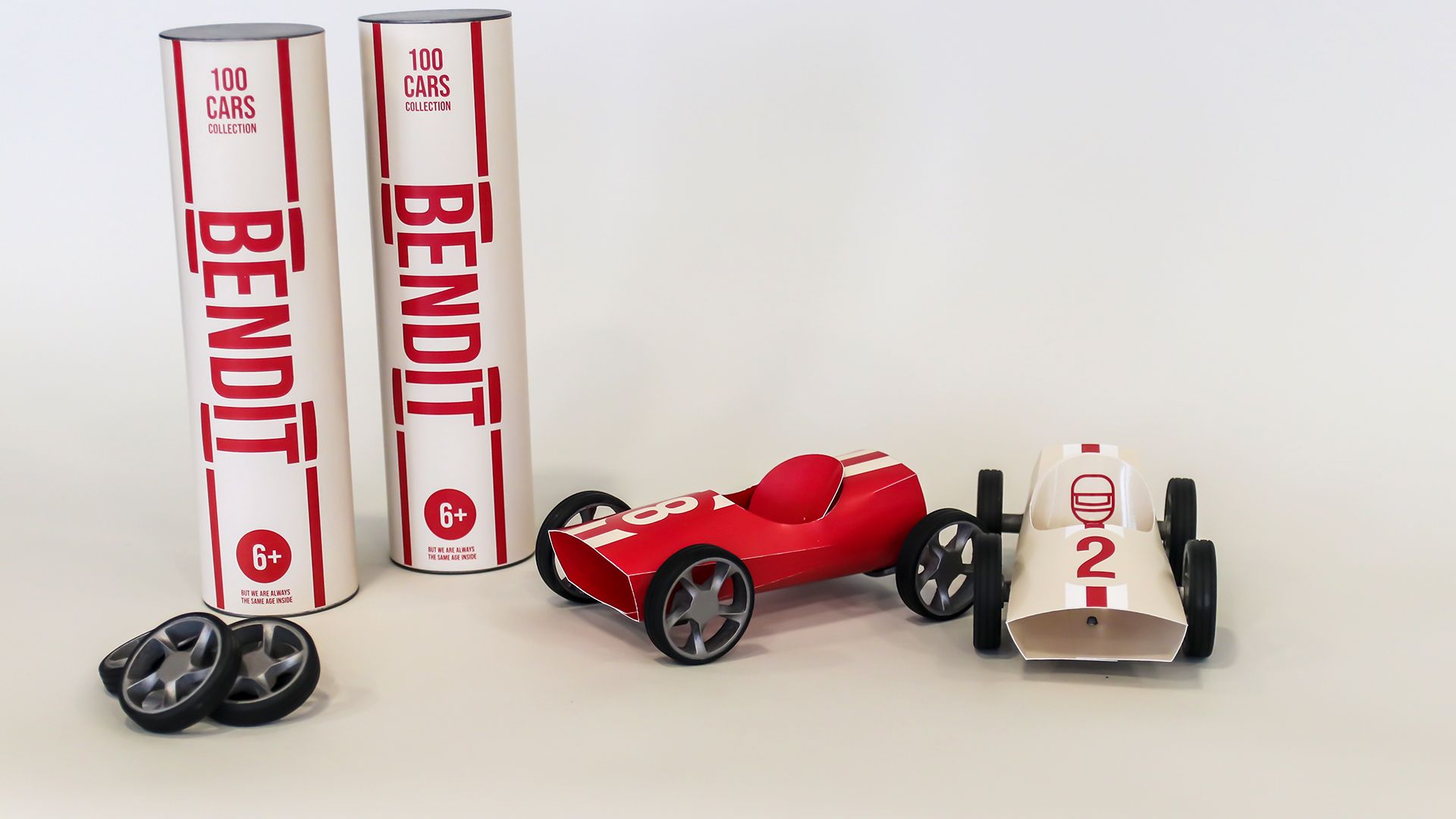 A red Bendit car and a white number-2 car next to the BENDIT packaging tubes.