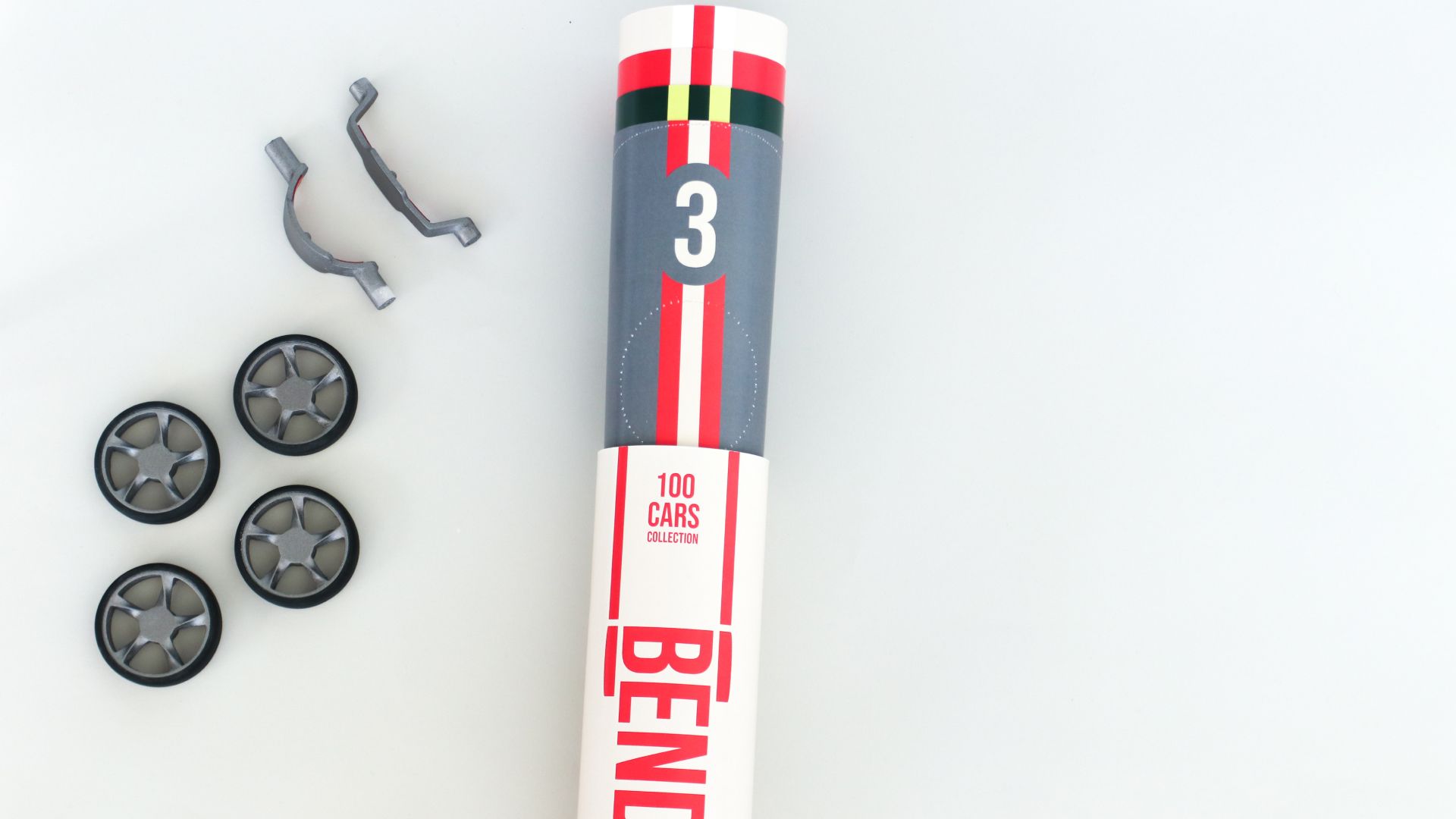A grey number-3 Bendit cardboard blank with its separate wheels and axle clips laid out.