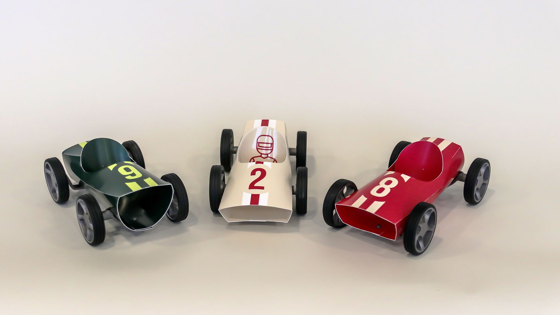 Three Bendit cars lined up — green number-9, white number-2 and red number-8.